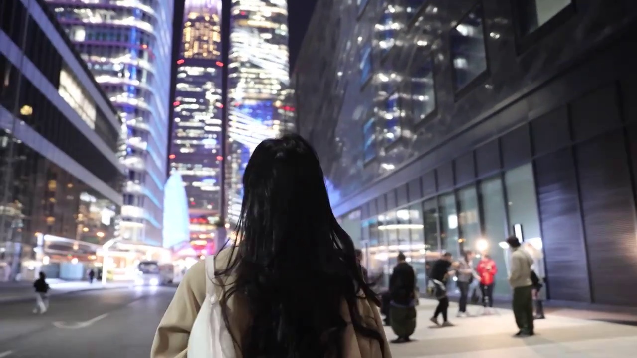 夜晚高知商务女子在城市街道上仰头欣赏城市夜景视频下载