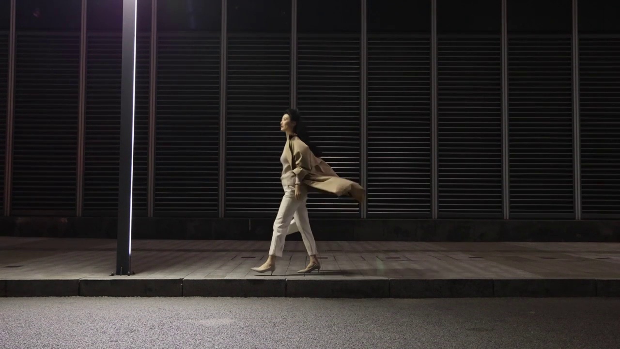 夜晚下班后，高知商务女性走在城市金融区路边视频下载
