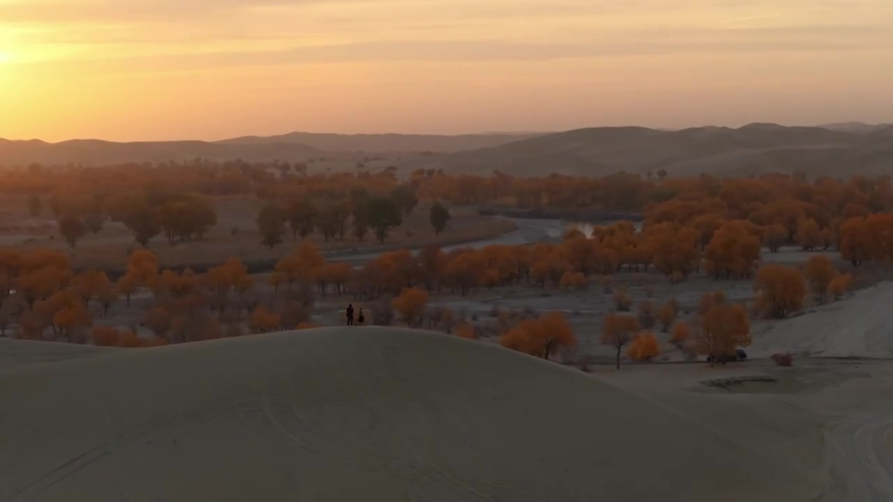 航拍摄影师站在新疆罗布湖景区的沙丘上视频下载