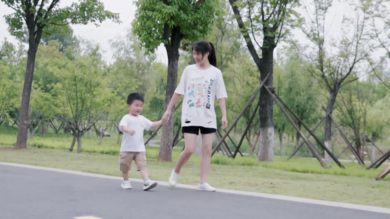 4K妈妈带着儿子在公园散步合集视频素材