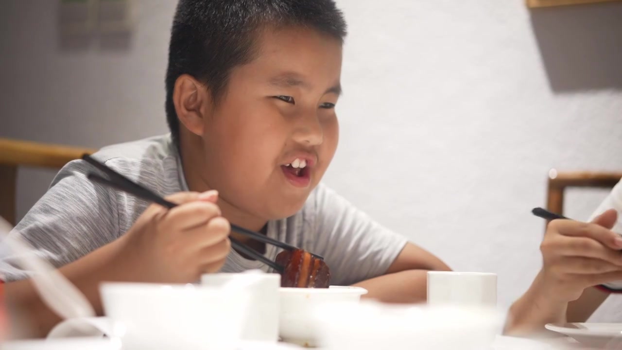 用筷子吃红烧肉的小男孩视频素材