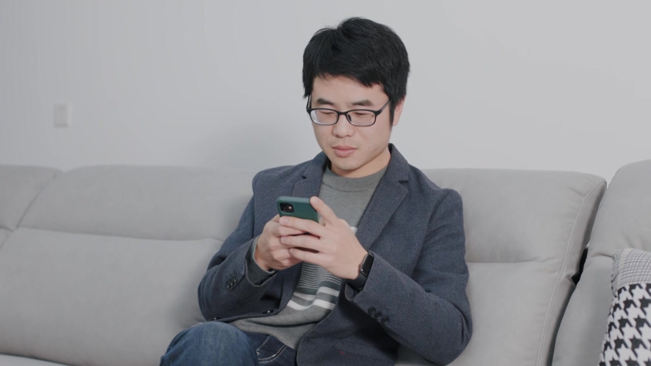 4K年轻男性在家坐沙发上玩手机视频下载