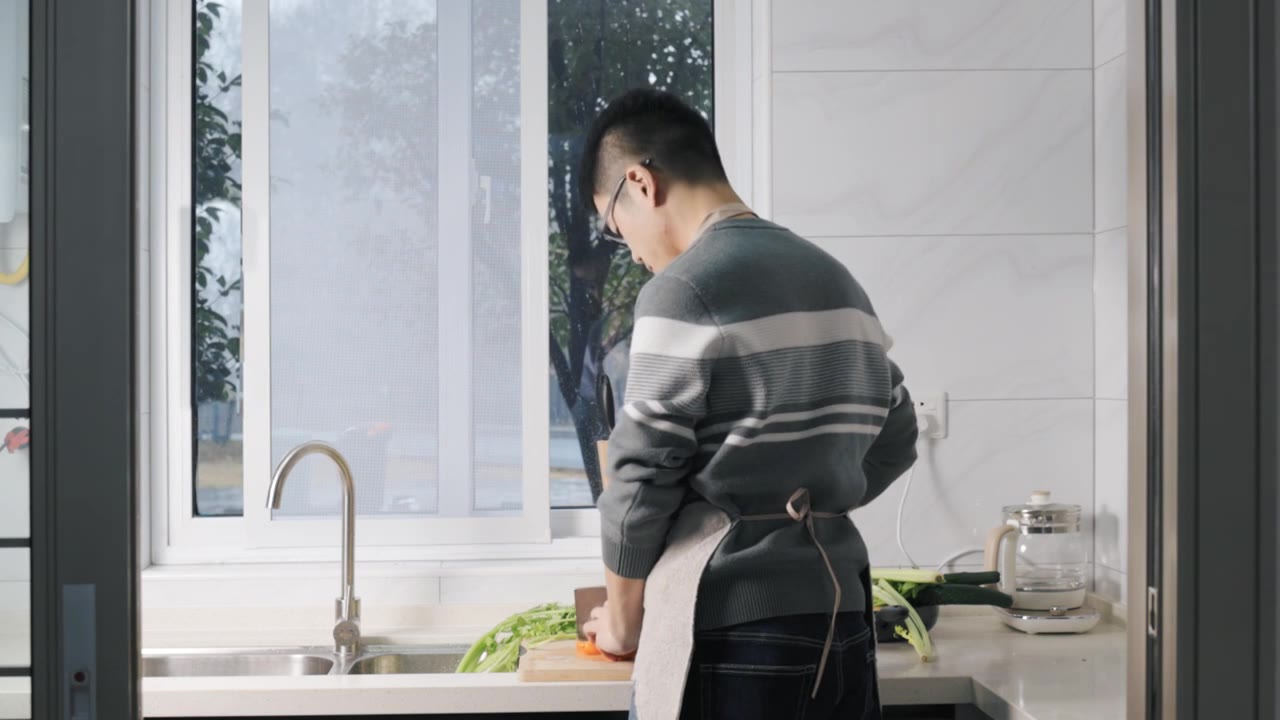 4K年轻男性在厨房切菜背影视频下载
