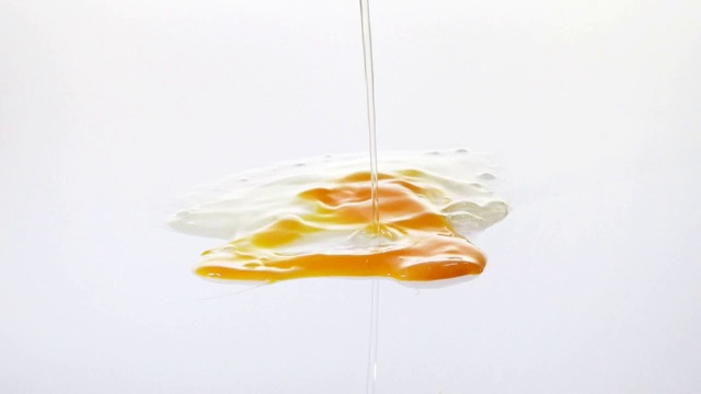 蛋白和蛋黄在白色表面上流动视频下载