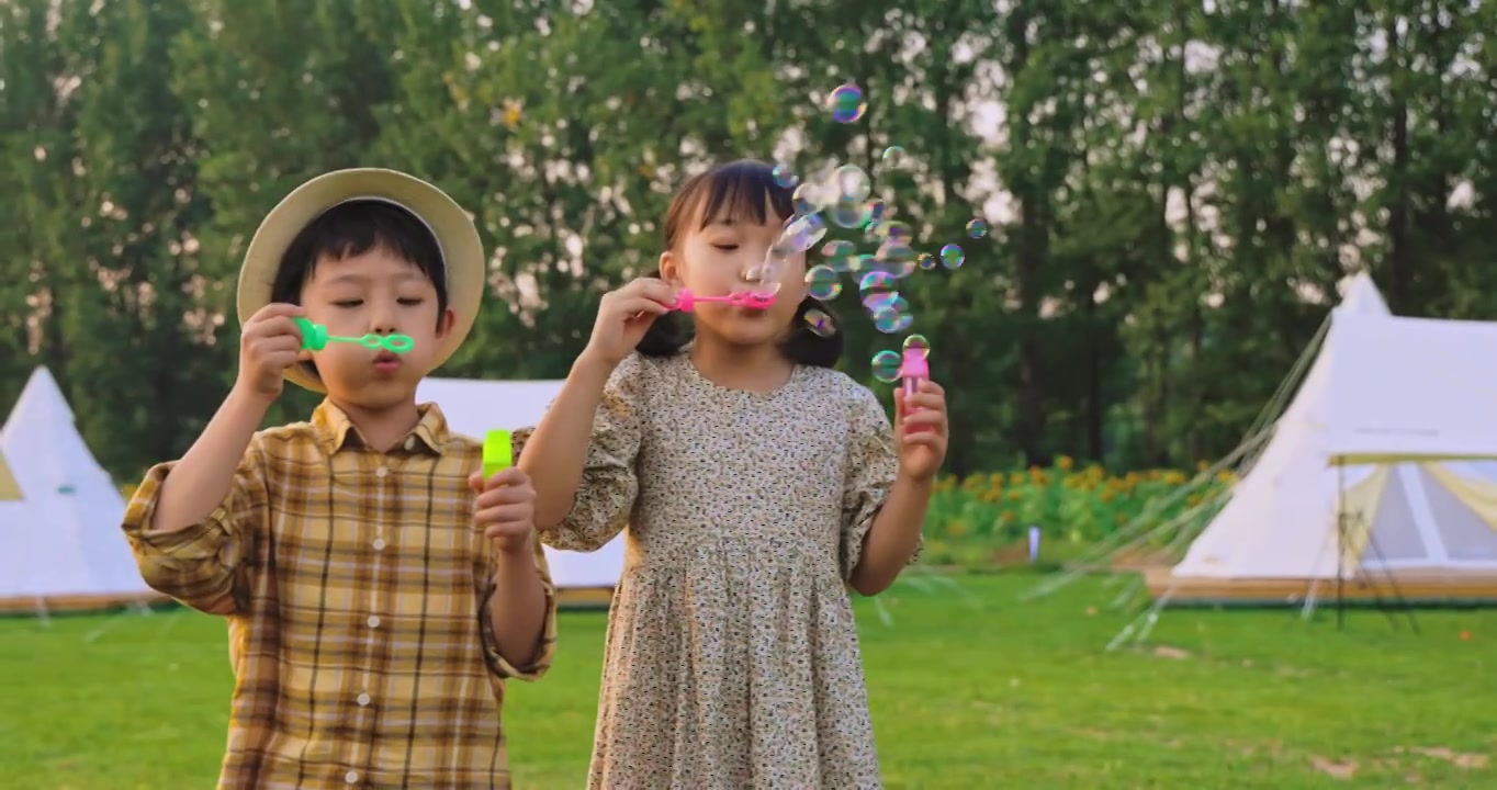 两个小孩在草地上吹泡泡视频下载