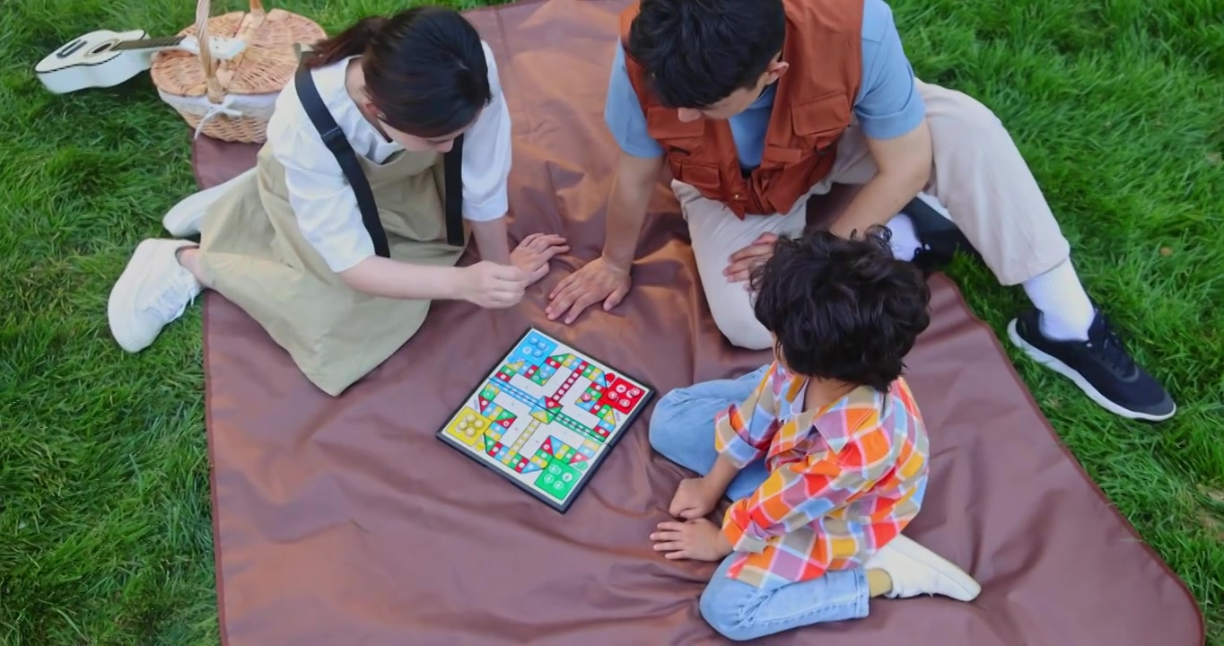 一家三口坐在野餐垫开心玩游戏视频下载