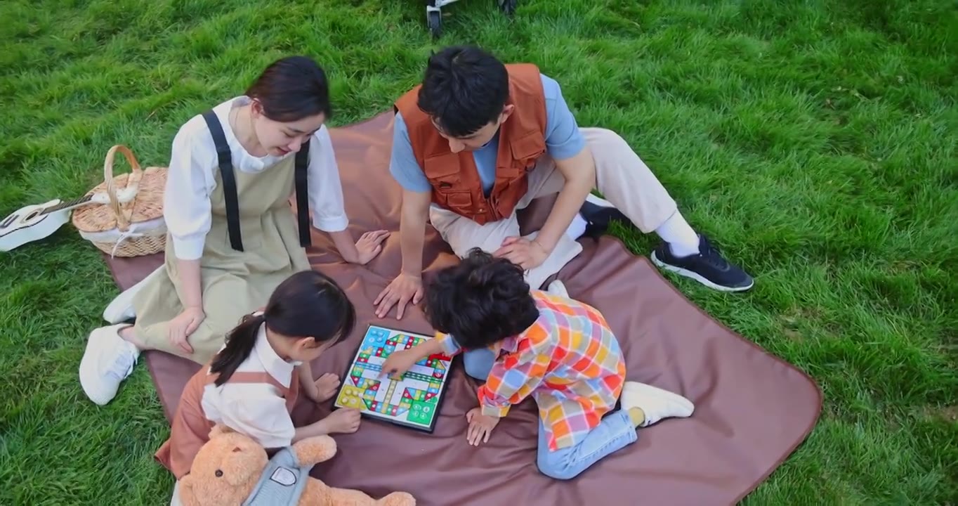 一家四口坐在野餐垫开心玩游戏视频下载