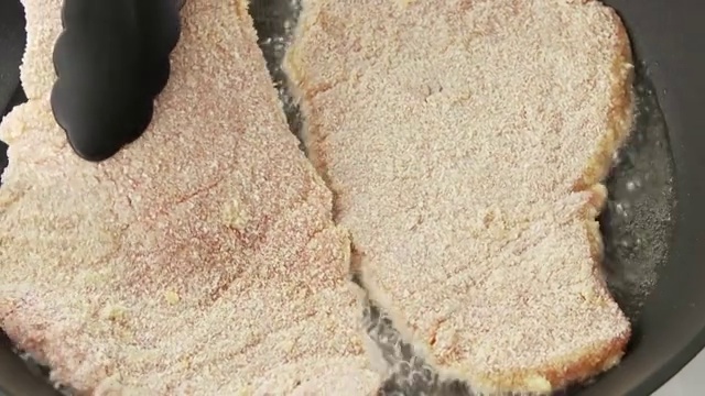 烤肉排在平底锅里煎的裹着面包屑的肉排视频下载