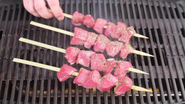 腌好的羊肉串放在烤肉架上视频素材