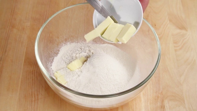 将黄油片加入筛过的面粉中视频素材