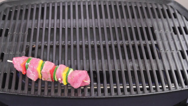 肉串和蔬菜串被放在烤架上视频素材