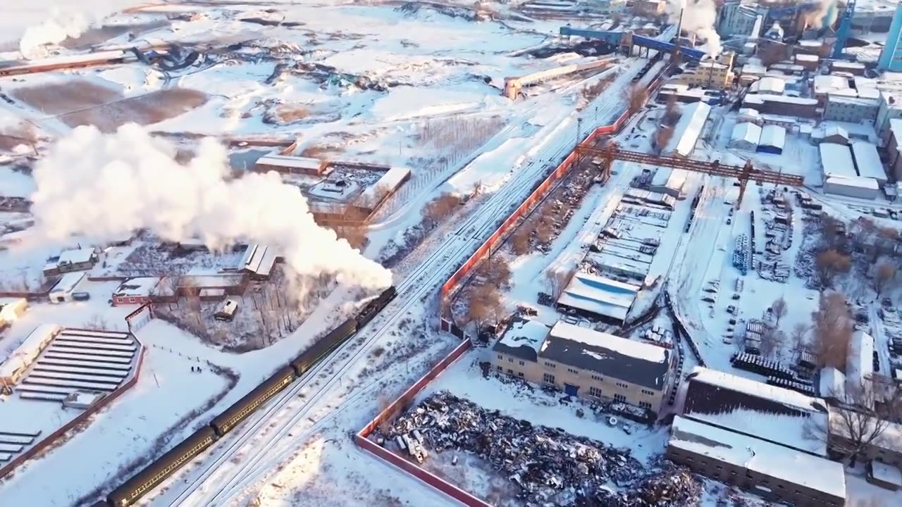 航拍中国东北冬季雪景中的蒸汽火车穿过村庄视频下载