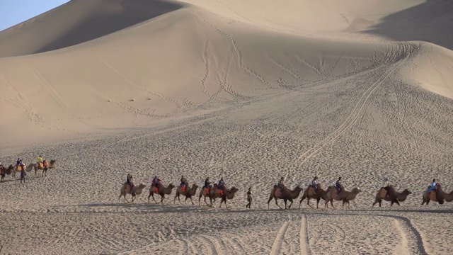 敦煌鸣沙山公园乘骑骆驼视频素材