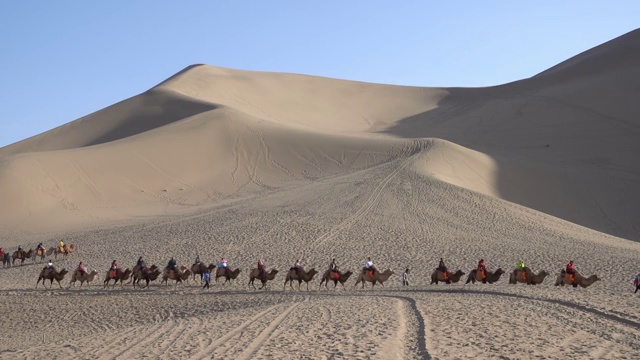 敦煌鸣沙山公园乘骑骆驼视频素材