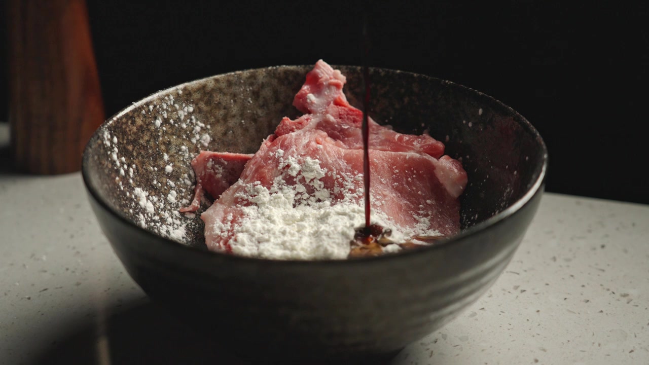 在碗中的猪肉上加入酱油生抽腌制视频下载