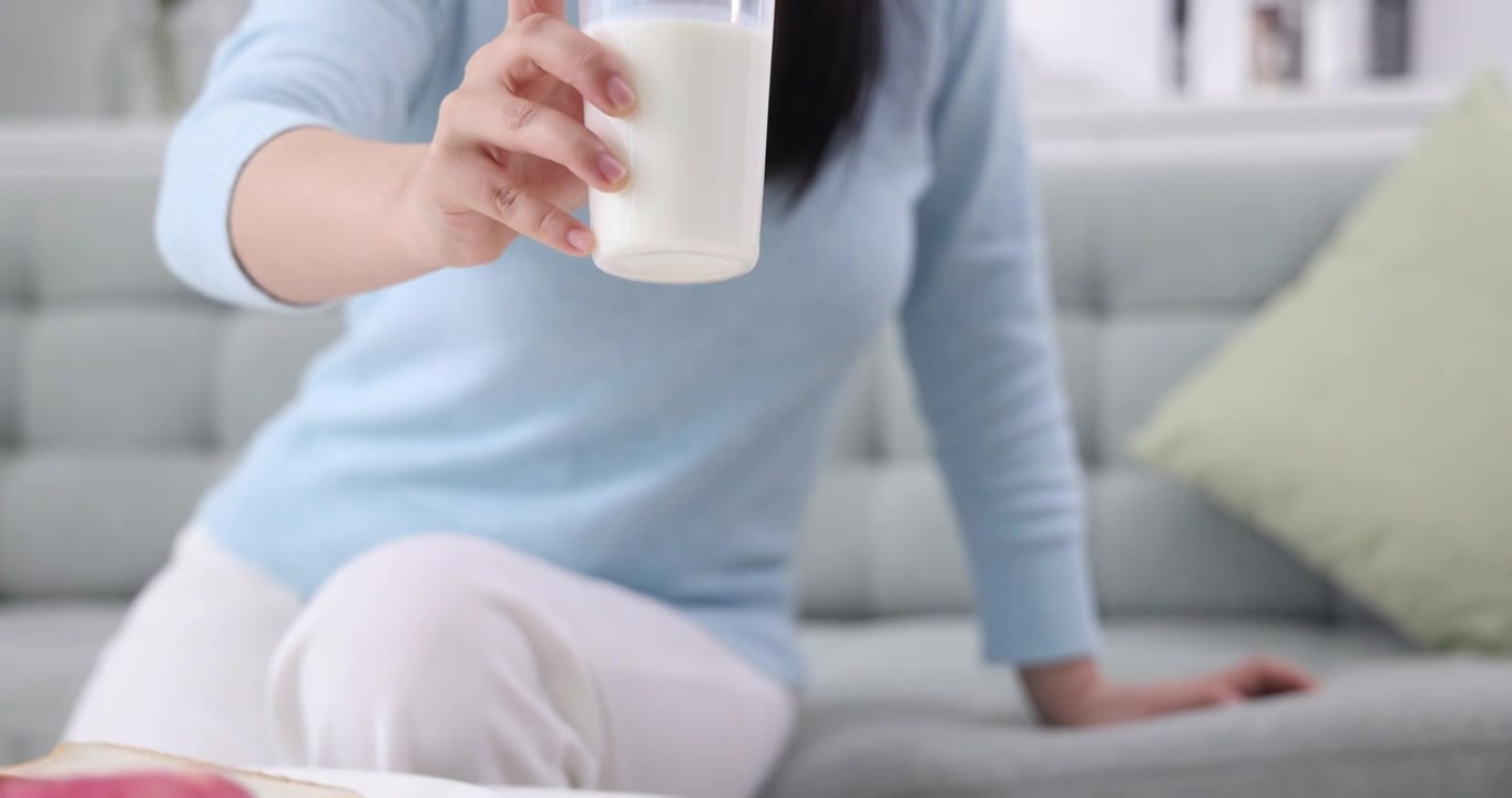 一位女士在起居室喝牛奶视频素材