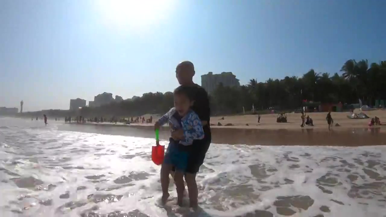 海南琼海博鳌海滩人像：爷爷带着孙子在海滩上冲浪玩耍视频素材