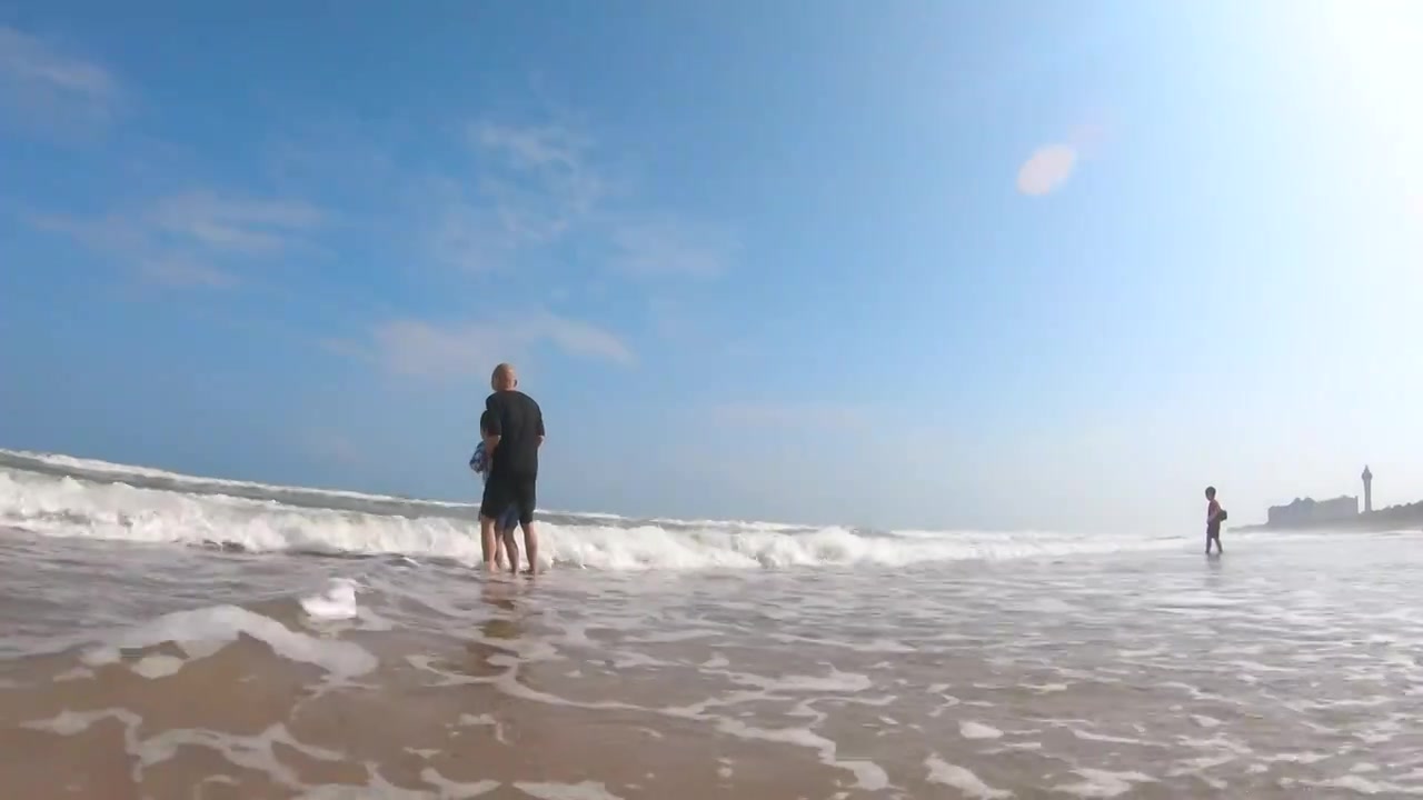 海南琼海博鳌海滩人像：爷爷带着孙子在海滩上冲浪玩耍视频下载