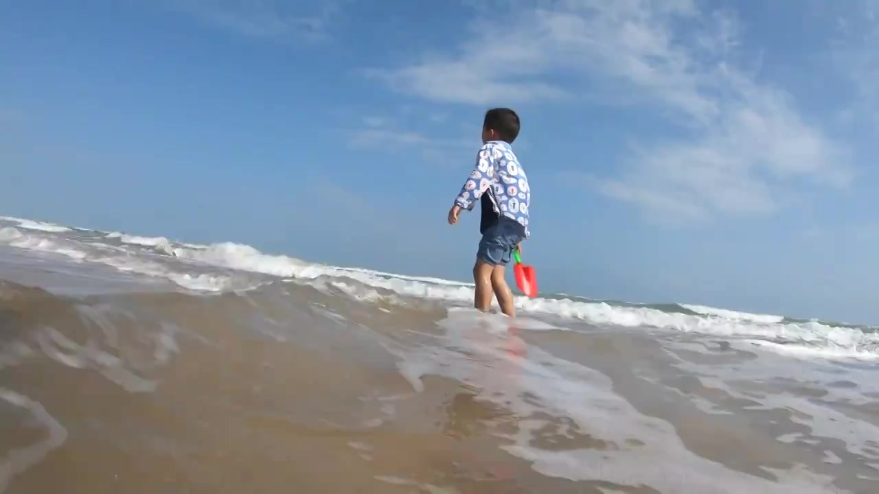 海南琼海博鳌海滩人像：爷爷带着孙子在海滩上冲浪玩耍视频素材