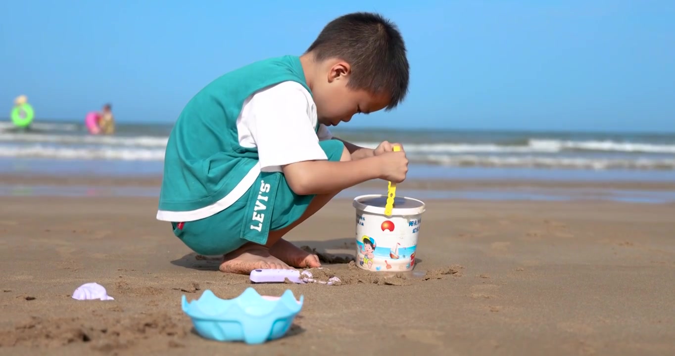 小男孩在海南临高角风景区的海滩上玩沙视频下载