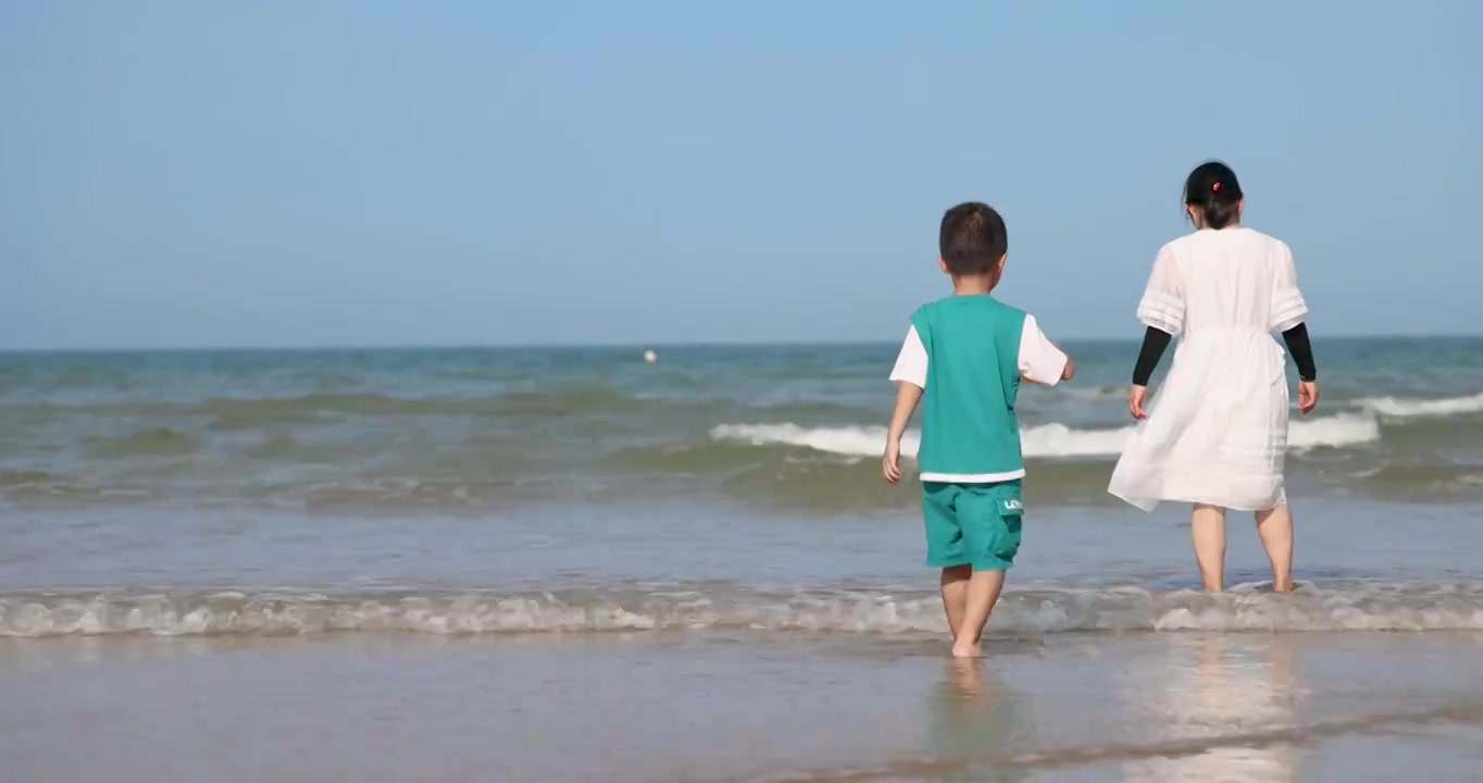 小男孩和母亲在海南临高角风景区的海滩上玩沙视频下载