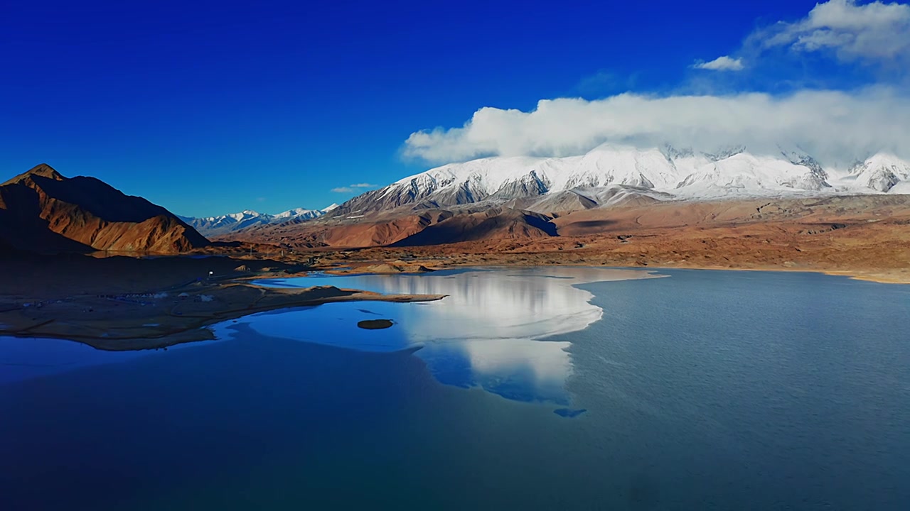 航拍中国新疆帕米尔高原喀拉库勒湖与公格尔峰公格尔九别峰视频素材