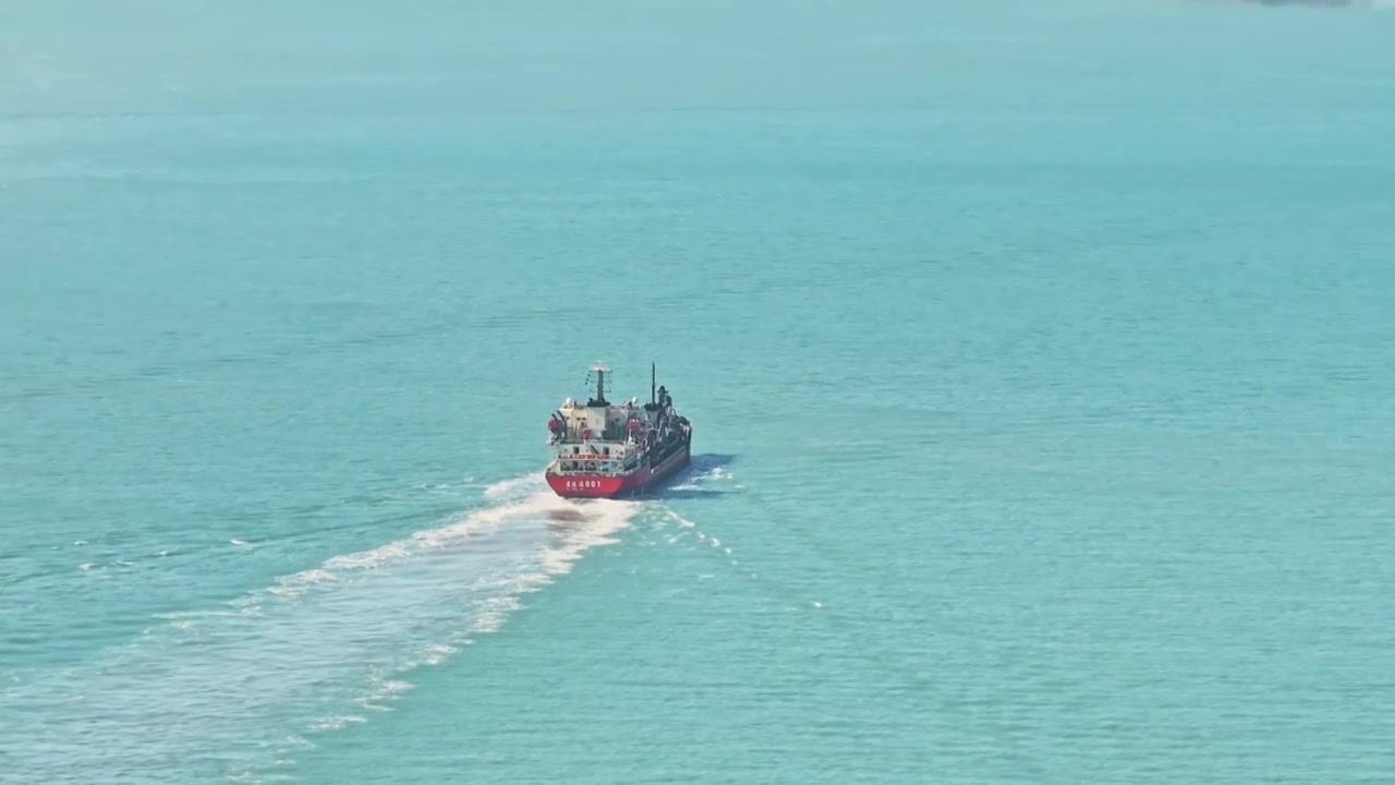 航拍蓝绿青色的海水面上一艘船视频下载