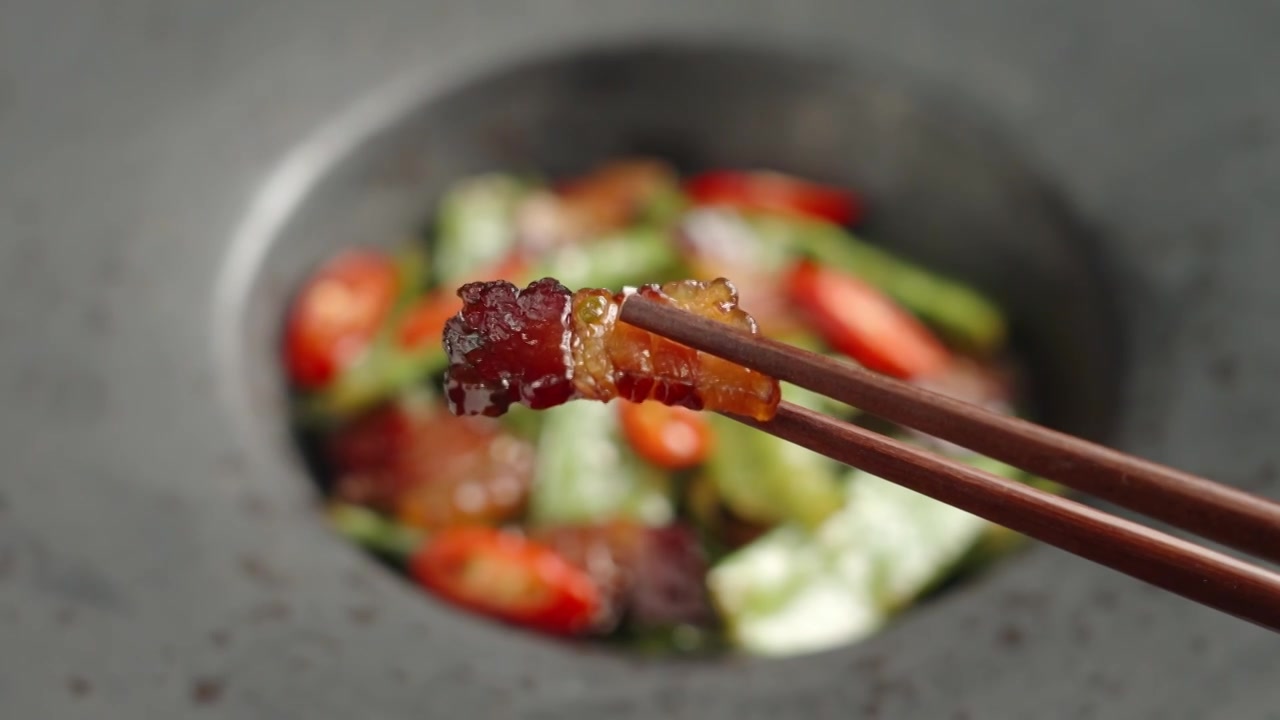筷子夹起一片腊肉美食特写视频下载