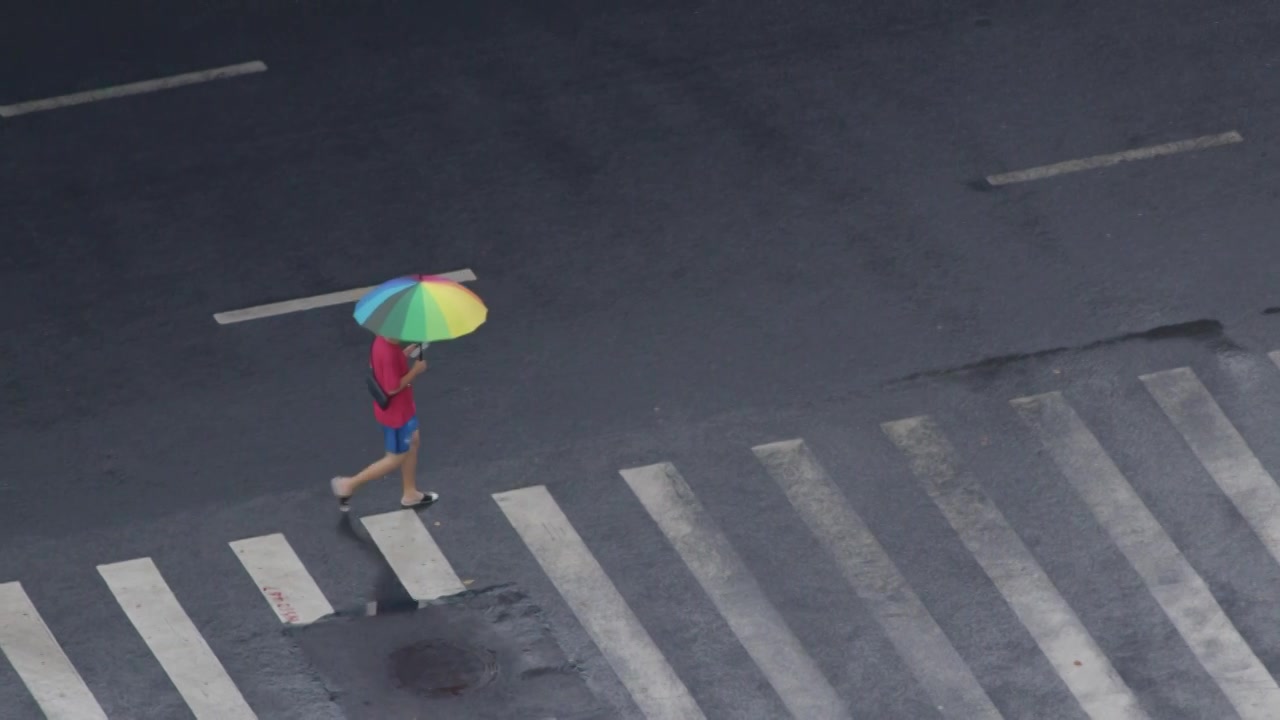 夏日雨后年轻人撑伞过马路视频素材