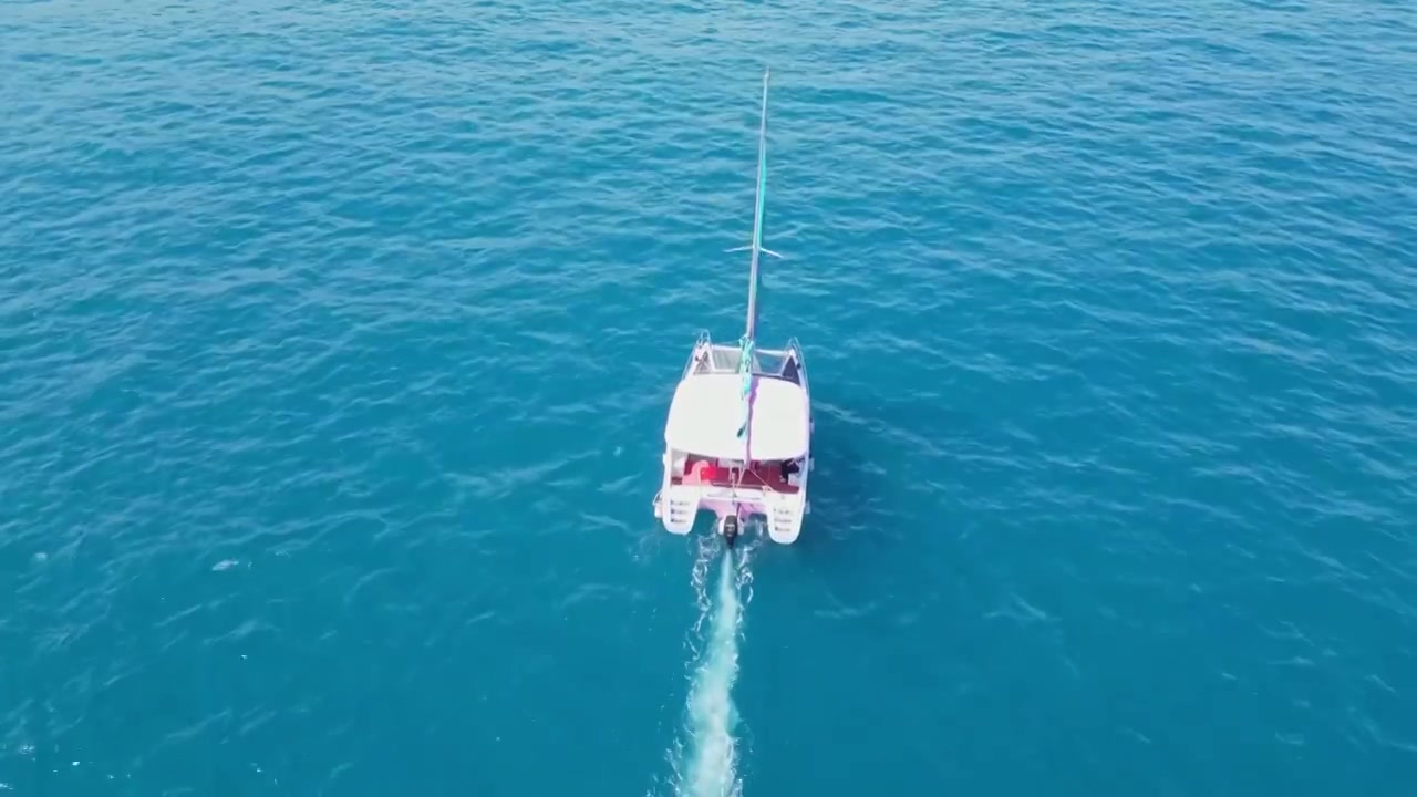 海南三亚高视角航拍西沙海洋蔚蓝色干净大海与行驶的帆船视频下载