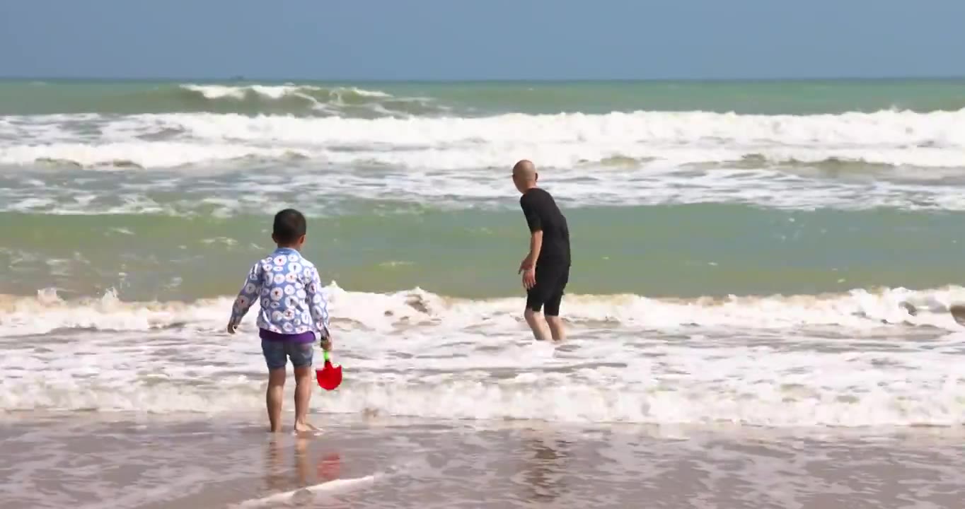 海南琼海博鳌海滩人像：爷爷带着孙子在海滩冲浪玩耍视频下载