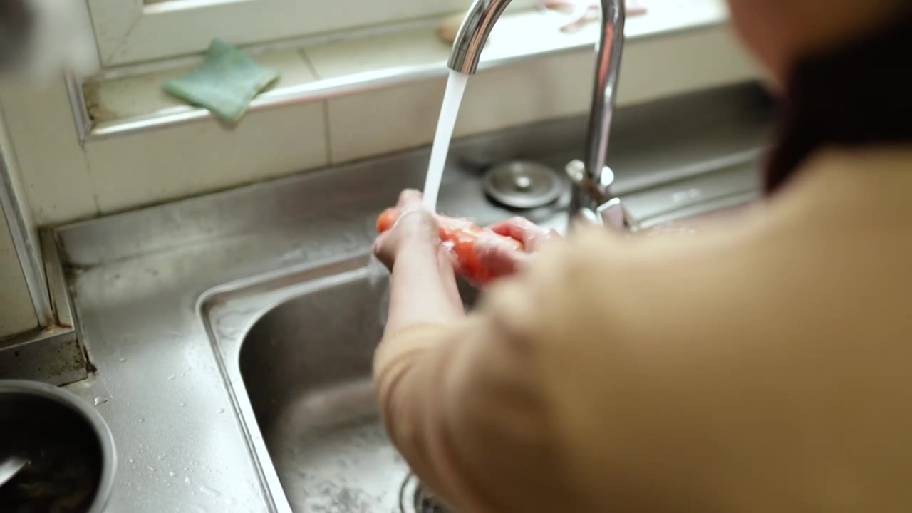 一个亚洲家庭主妇在家里洗菜视频下载
