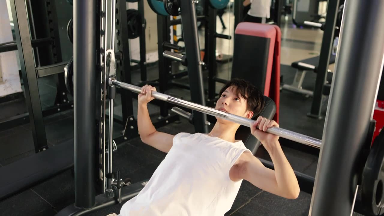 一个亚洲男性在健身房锻炼手臂视频素材