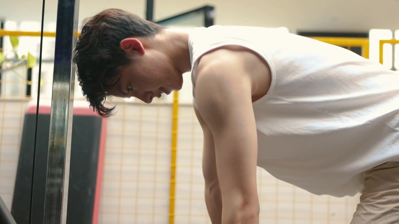 一个亚洲男人在健身房使用哑铃锻炼视频下载