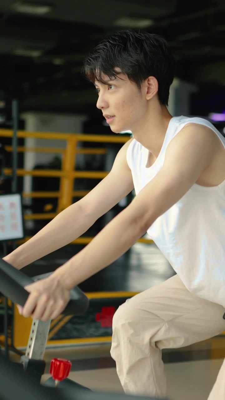 一个亚洲男人在室内骑行自行车锻炼视频素材