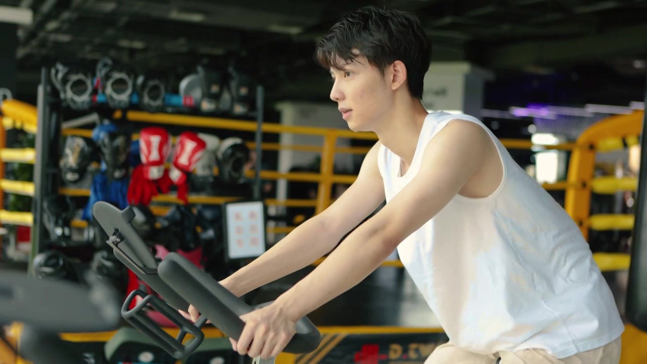 一个亚洲男人在室内骑行自行车锻炼视频下载