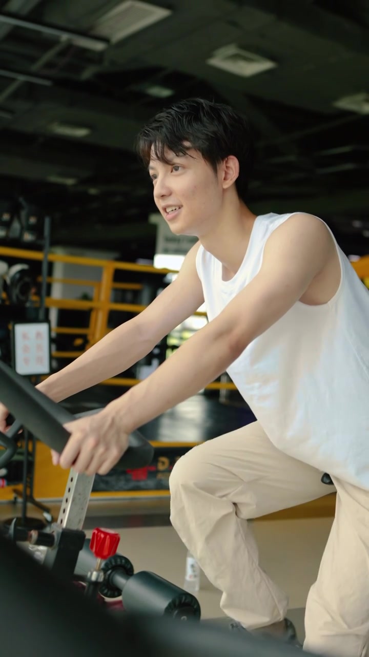 一个亚洲男人在室内骑行自行车锻炼视频素材