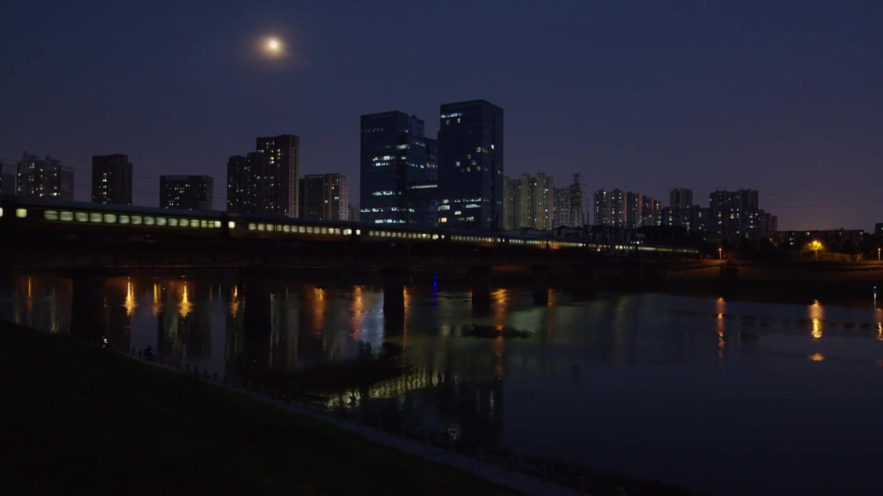 绿色客运列车夜晚驶过长沙浏阳河大桥视频素材