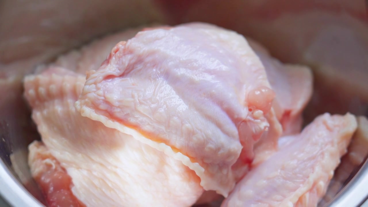 一个女人制作鸡翅土豆条中给鸡翅去骨头视频下载