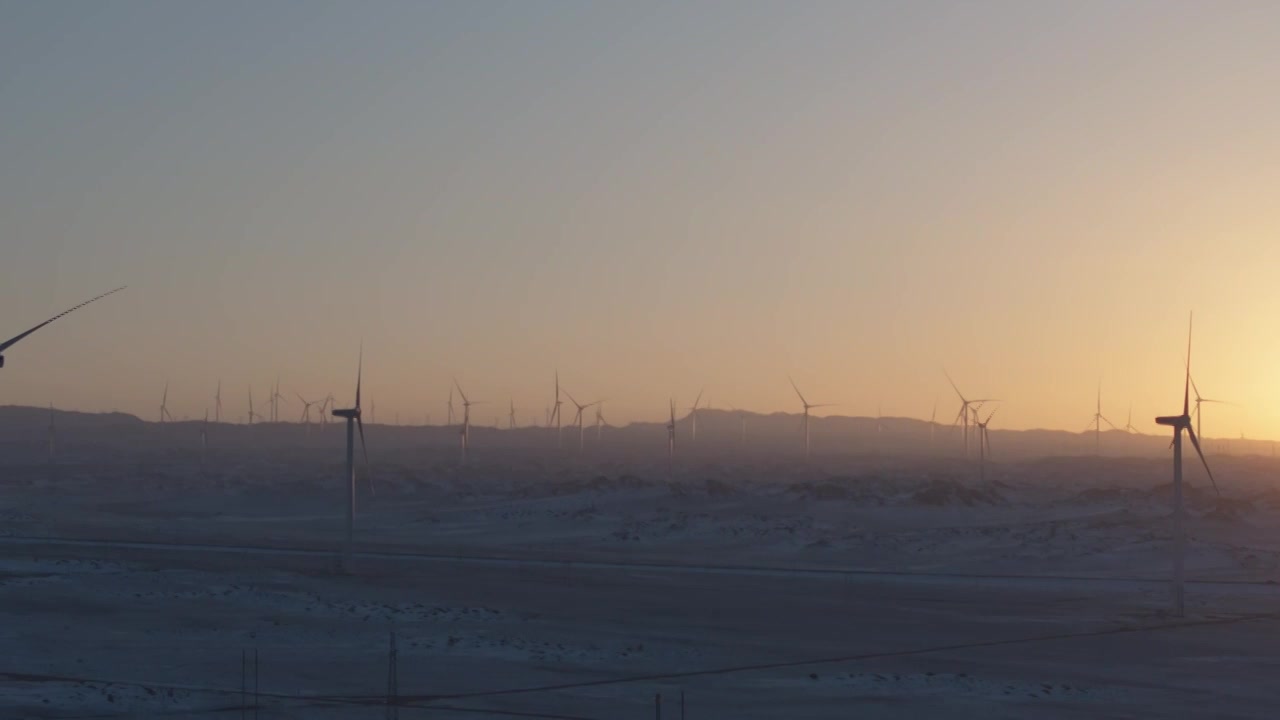 航拍新疆阿勒泰冬季雪原夕阳日落时分晚霞戈壁风电场风电风机风车清洁能源视频下载