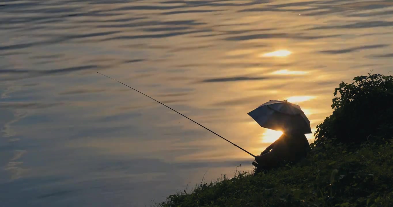 江边头戴遮阳伞的钓鱼翁视频素材