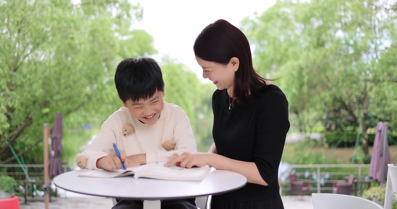 妈妈陪着小孩在户外快乐学习写作业视频下载