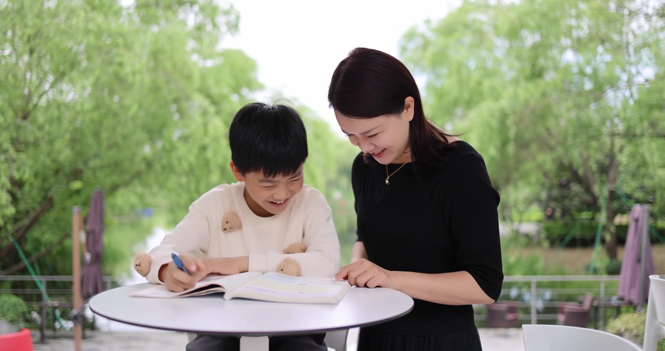 妈妈陪着小孩在户外快乐学习写作业视频下载