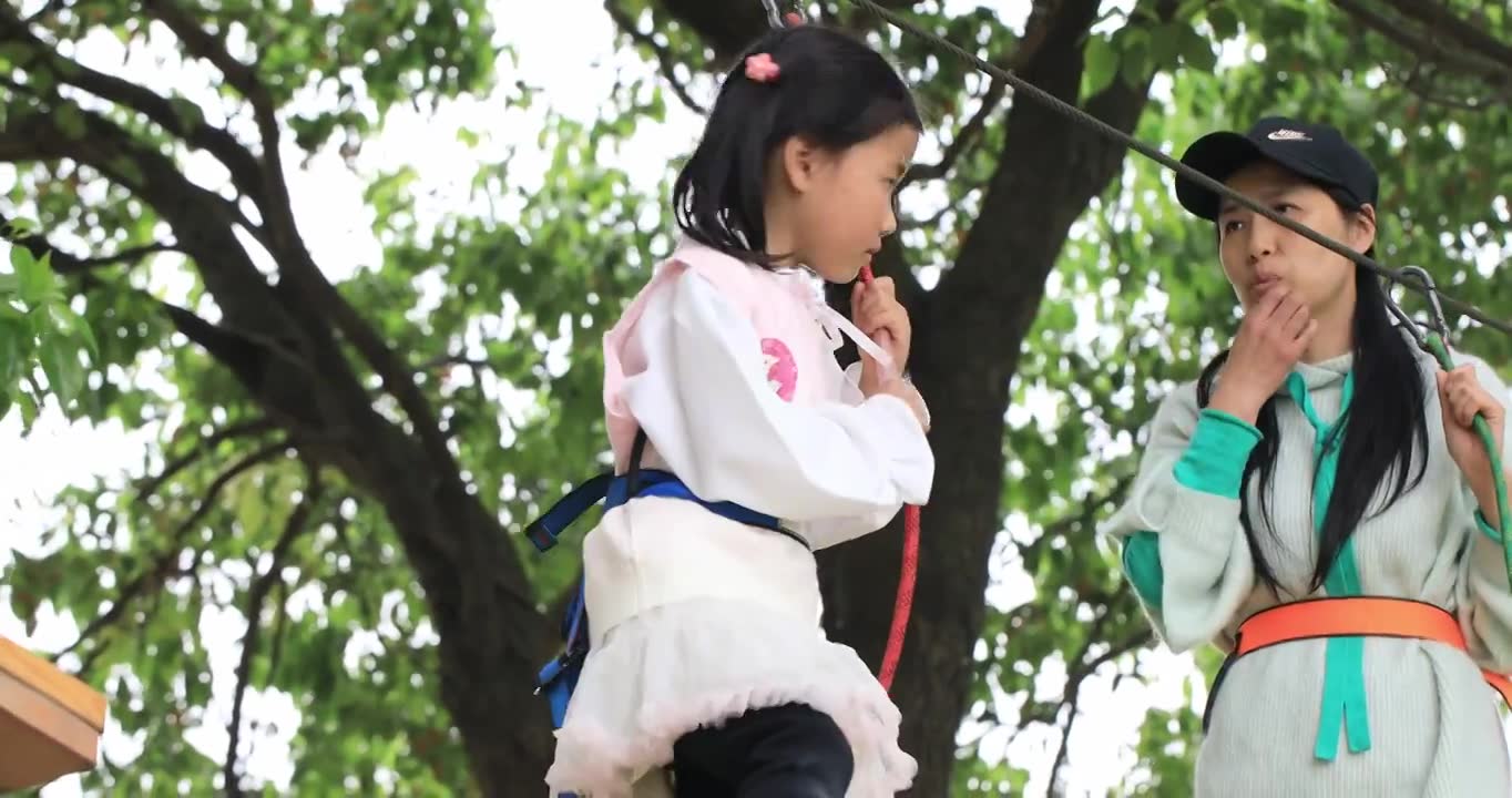 勇敢的小女孩系着安全带与妈妈一起 在高空行走过障碍物挑战自我视频下载