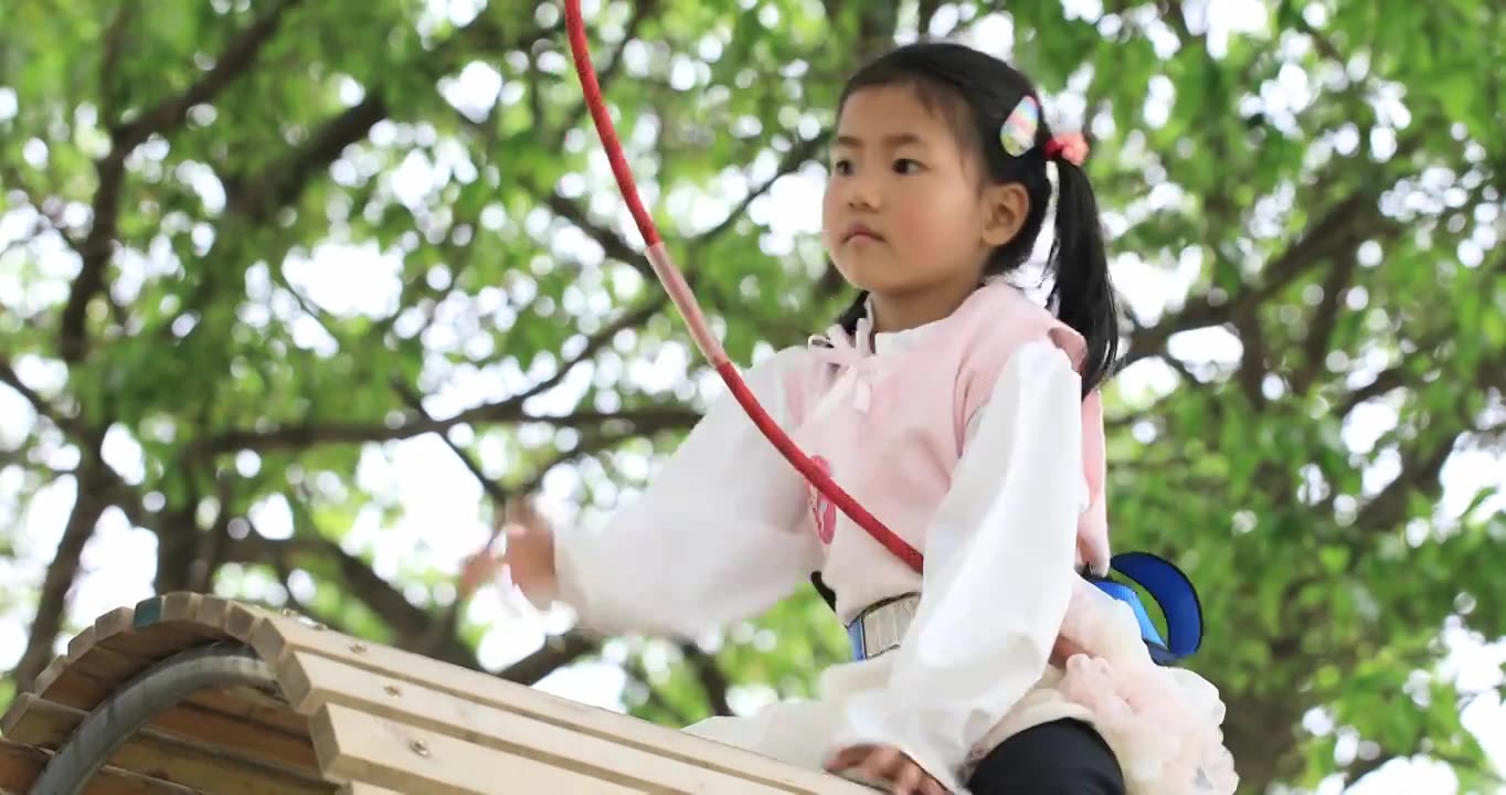 勇敢的小女孩系着安全带 在高空行走过障碍物挑战自我视频下载