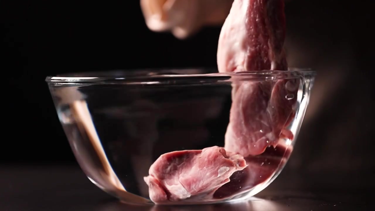 将猪肉放入到玻璃盆里浸泡、清洗视频下载