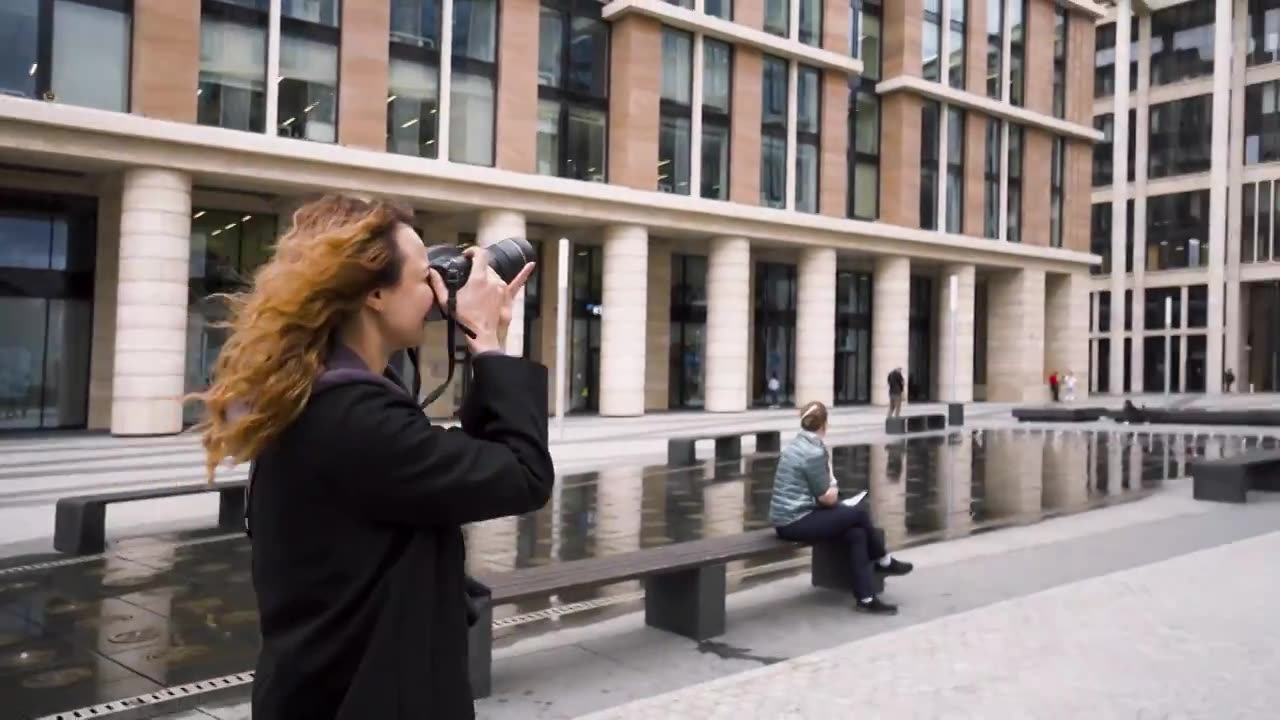 一名妇女用商业大楼的专业相机拍照。行动视频下载