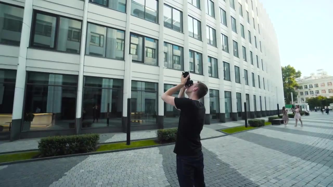 摄影师拍摄城市的现代建筑。行动。年轻人视频下载