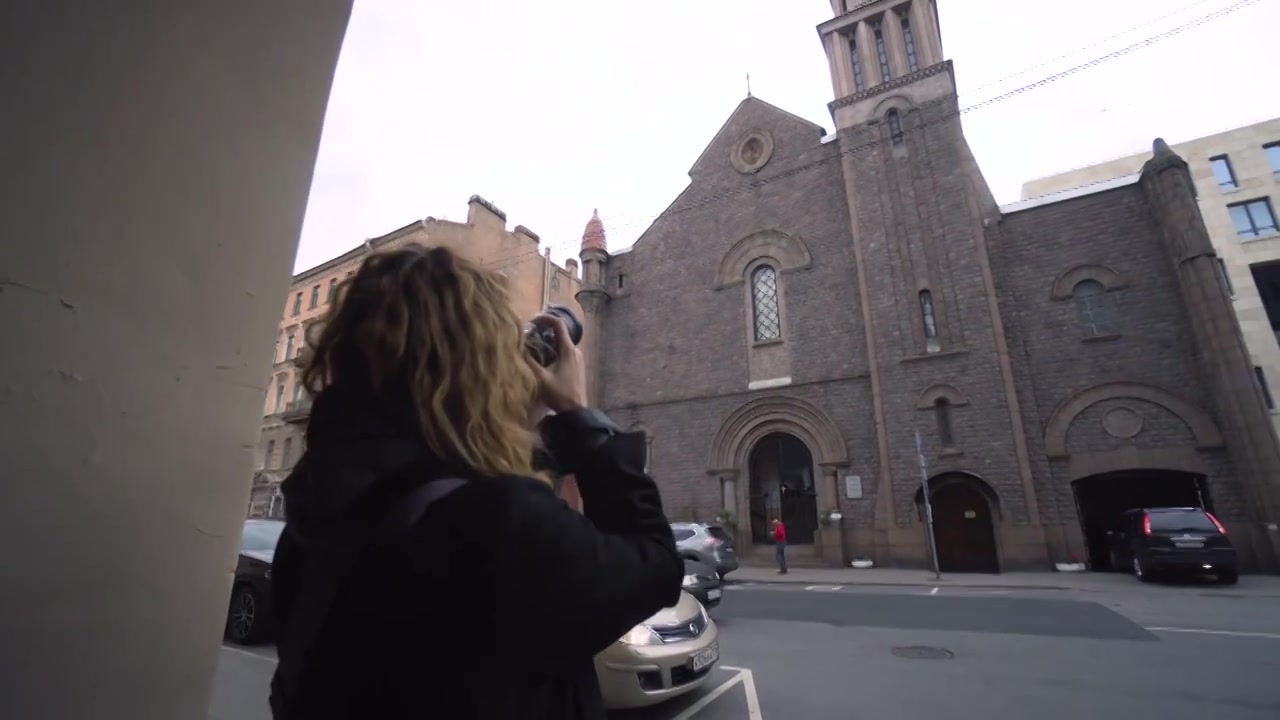 女子用相机拍摄天主教堂。行动。女摄影师视频下载