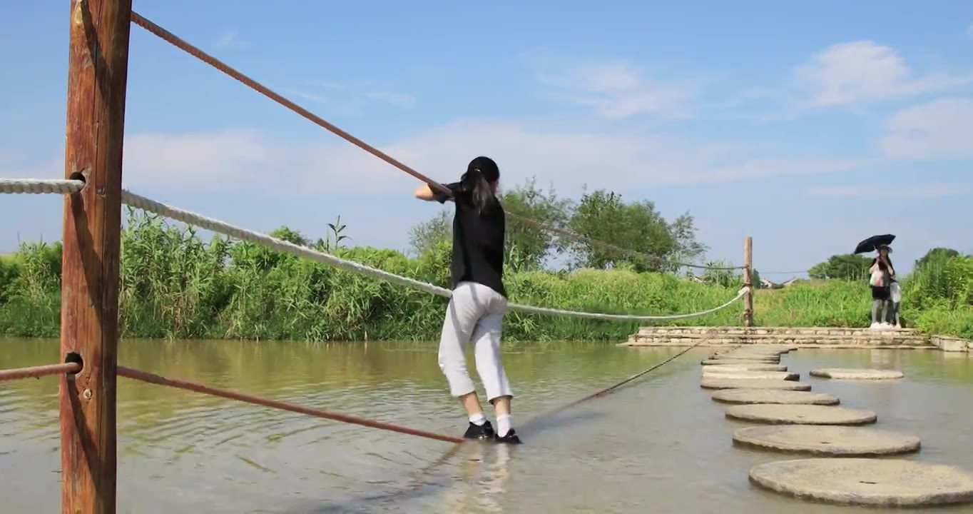 女孩踩着水面的绳子 试图走过水面玩耍 开心笑容视频下载